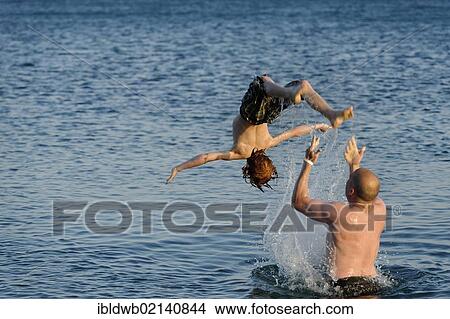 Father and son splashing around in the sea View Large Photo Image Picture - Father and son splashing around in the sea. Fotosearch