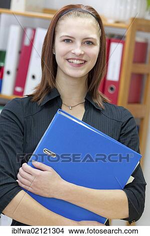 Female office worker holding blue folder View Large Photo Image Picture - Female office worker holding blue folder. Fotosearch