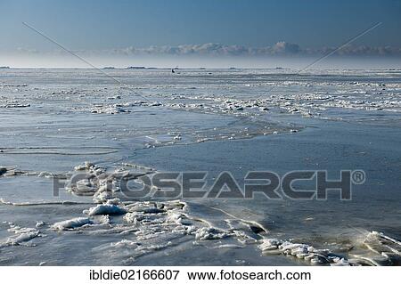Stock Photo - Frozen North Sea with the Hallig Hooge, holm, on the horizon, North Frisia, Schleswig-Holstein, Northern Germany, Germany, Europe. Fotosearch