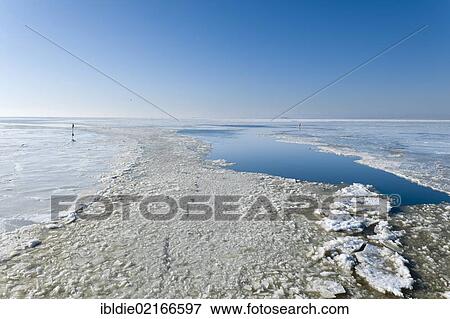 Stock Photo - Frozen North Sea with the Hallig Oland, holm, on the horizon, North Frisia, Schleswig-Holstein, Northern Germany, Germany, Europe. Fotosearch