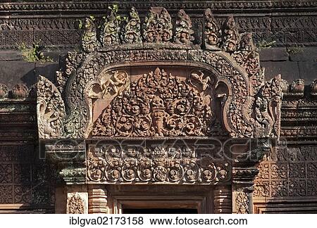 Gable ornament depicting Kubera, the God of Wealth, appearing in his capacity as the Guardian of the North, sitting above Rahu devouring an elephant, northern door of the Mandapa, the central sanctuary, Banteay Srei Temple, Citadel of the Women,... View Large Photo Image Stock Photo - Gable ornament depicting Kubera, the God of Wealth, appearing in his capacity as the Guardian of the North, sitting above Rahu devouring an elephant, northern door of the Mandapa, the central sanctuary, Banteay Srei Temple, Citadel of the Women,.... Fotosearch