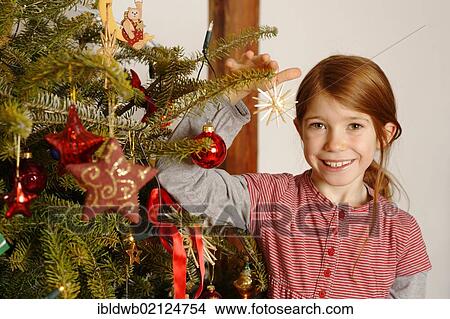 Picture - Girl with a Christmas tree. Fotosearch