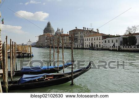 Stock Image - Gondolas, Grand Canal, Canal or Canale Grande, church of Santa Maria della Salute at back, Venice, Italy, Europe. Fotosearch
