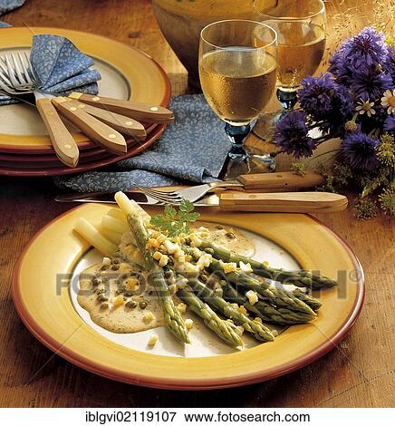 Stock Photo - Green asparagus with a spicy sauce, delicate chervil, spicy capers and mustard, cold starter, France, Europe. Fotosearch