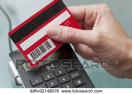 Hand holding an electronic card against a reader View Large Photo Image Stock Photograph - Hand holding an electronic card against a reader. Fotosearch