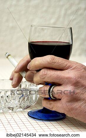 Hands holding cigarette and glass of red wine View Large Photo Image Picture - Hands holding cigarette and glass of red wine. Fotosearch