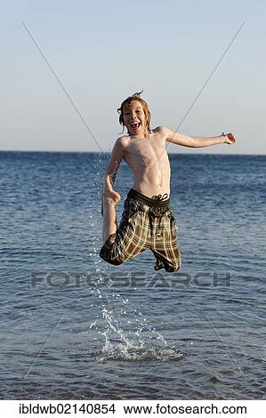 Happy boy jumping in the sea View Large Photo Image Picture - Happy boy jumping in the sea. Fotosearch