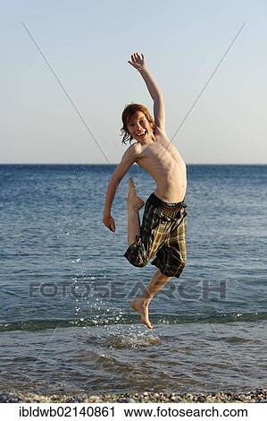 Happy boy jumping in the sea View Large Photo Image Stock Image - Happy boy jumping in the sea. Fotosearch