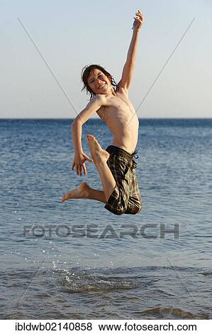 Happy boy jumping in the sea View Large Photo Image Stock Photo - Happy boy jumping in the sea. Fotosearch