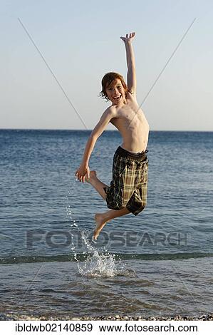 Happy boy jumping in the sea View Large Photo Image Stock Photo - Happy boy jumping in the sea. Fotosearch