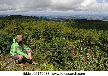 Stock Image - Hiker on the rocks of Koenigsstuhl, Donnersberg Mountain, highest peak of the Palatinate, North Palatine, Rhineland-Palatinate, Germany, Europe. Fotosearch