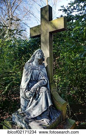 Historical gravestone with a statue and a cross at Ohlsdorf Cemetery in Hamburg, Germany, Europe View Large Photo Image Picture - Historical gravestone with a statue and a cross at Ohlsdorf Cemetery in Hamburg, Germany, Europe. Fotosearch