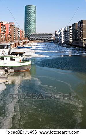 Stock Photograph - Ice on the Main River in Frankfurt's West Harbour, looking towards Westhafen Tower, nicknamed Apple Wine Tower after the shape of a typical Frankfurtian cider glass, Frankfurt am Main, Hesse, Germany, Europe. Fotosearch