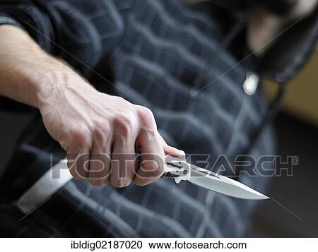 Knife crime, hooded male person brandishing a butterfly knife View Large Photo Image Stock Image - Knife crime, hooded male person brandishing a butterfly knife. Fotosearch