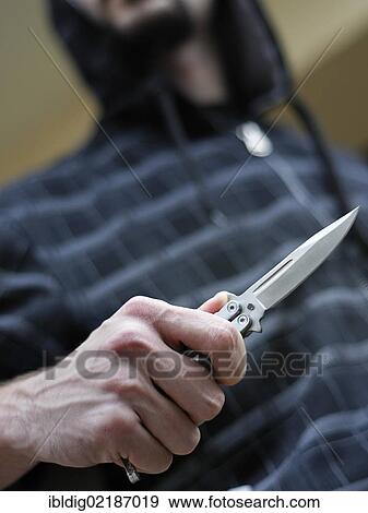 Knife crime, hooded male person brandishing a butterfly knife View Large Photo Image Stock Photo - Knife crime, hooded male person brandishing a butterfly knife. Fotosearch