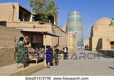 Stock Image - Lane in the historic Ichan Kala adobe oldtown of Khiva, Chiva with Kalta Minor minaret, Silk Road, Unesco World Heritage Site, Uzbekistan, Central Asia, Asia. Fotosearch
