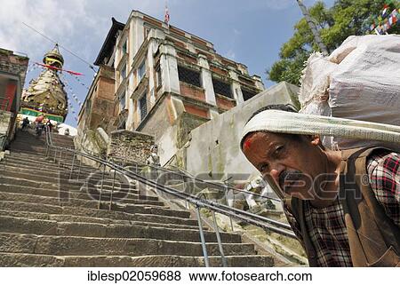 Stock Photo - Man carrying load on back, Swayambhunath temple, Kathmandu, Nepal, Asia. Fotosearch