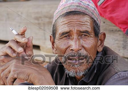 Man with a hat holding a cigarette, portrait, Bhaktapur, Kathmandu Valley, Nepal, Asia View Large Photo Image Stock Photo - Man with a hat holding a cigarette, portrait, Bhaktapur, Kathmandu Valley, Nepal, Asia. Fotosearch