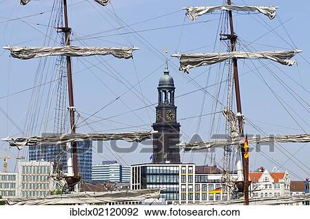 Stock Image - Masts of a historic tall ship in front of the tower of St. Michaelis Church, Michel, during the harbour anniversary celebrations in 2011, Hamburg, Germany, Europe. Fotosearch