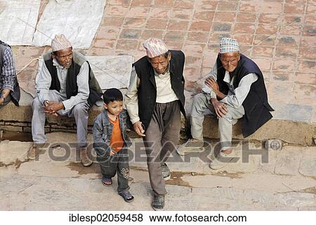 Stock Photo - Men with traditional headwear and boy on the Taumadhi square, Bhaktapur, Kathmandu Valley, Nepal, Asia. Fotosearch