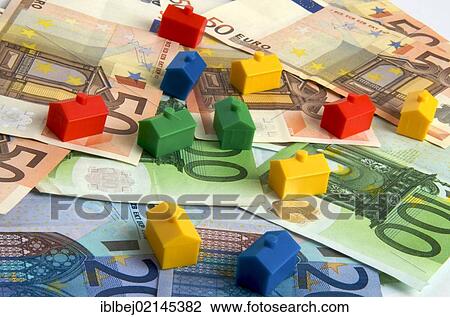 Stock Image - Miniature houses on euro notes, symbolic image real estate. Fotosearch