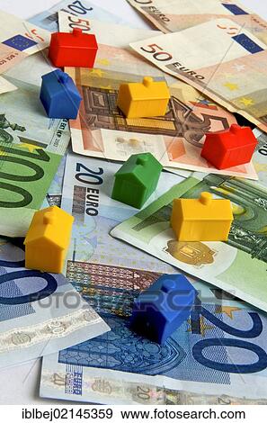 Stock Photo - Miniature houses on euro notes, symbolic image real estate. Fotosearch