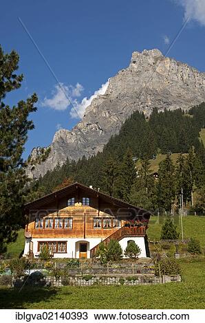 Stock Image - Modern home in the Swiss chalet-style at the foot of a mountain, Kandersteg, Bernese Oberland, Switzerland, Europe. Fotosearch