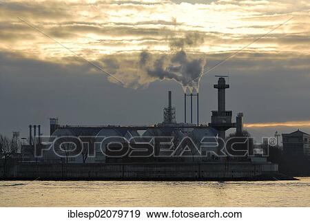 Stock Photo - Morning mood at the Port of Hamburg, digester towers of the Koehlbrandhoeft wastewater treatment plant, Elbe river, Hamburg, Germany, Europe, PublicGround, Europe. Fotosearch