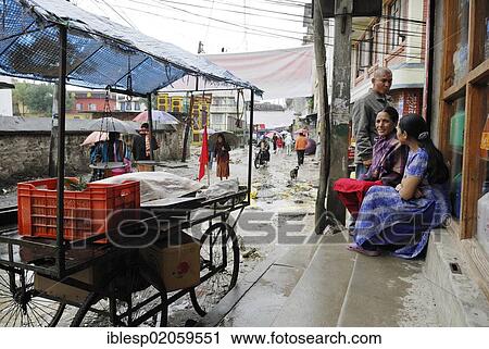 Stock Image - Nepali women in the rain on the streets of Kathmandu, Kathmandu, Nepal, Asia. Fotosearch