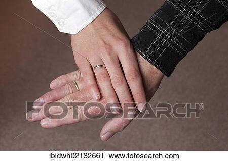 Stock Image - Old and young going hand in hand, young woman, 27, and man, 59. Fotosearch