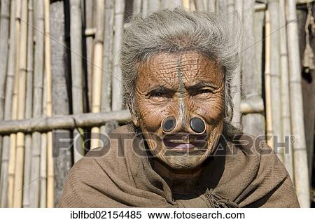 Old Apatani woman with the traditional noseplugs and tattoos, in front of her house, Hong village, Arunachal Pradesh, India, Asia View Large Photo Image Stock Photography - Old Apatani woman with the traditional noseplugs and tattoos, in front of her house, Hong village, Arunachal Pradesh, India, Asia. Fotosearch
