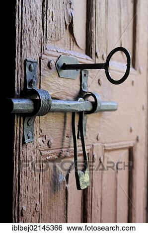 Stock Photograph - Old door of wood with its worn lock, Church in Cantal, Auvergne, France, Europe. Fotosearch
