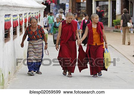 Stock Photo - Old woman and nuns walking around stupa of Bodhnath, Kathmandu, Nepal, Asia. Fotosearch