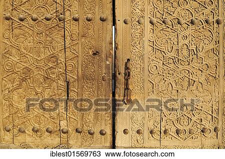 Stock Image - Old wooden gate of Kohna Ark citadel in the historic adobe town of Khiva, Chiva, Silk Road, Unesco World Heritage Site, Uzbekistan, Central Asia, Asia. Fotosearch