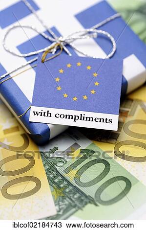Stock Image - Package wrapped in a Greek flag with a greeting card from the EU, symbolic image of the aid package for Greece. Fotosearch