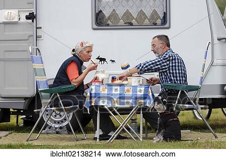 Pair with miniature Schnauzer eating at a table in front of a mobile home, Lower Saxony, Germany, Europe, Europe View Large Photo Image Picture - Pair with miniature Schnauzer eating at a table in front of a mobile home, Lower Saxony, Germany, Europe, Europe. Fotosearch
