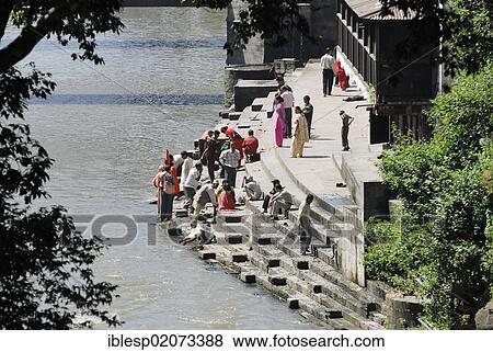 Pilgrims on the steps of the Pandra Shivalaya complex opposite the ghats of Pashupatinath on the holy Bagmati River, Kathmandu, Nepal, Asia View Large Photo Image Stock Photo - Pilgrims on the steps of the Pandra Shivalaya complex opposite the ghats of Pashupatinath on the holy Bagmati River, Kathmandu, Nepal, Asia. Fotosearch