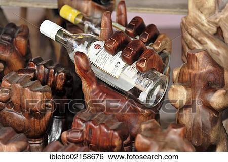 Stock Photograph - Rack for rum bottles, hands carved of wood, souvenirs, market stall, Trinidad, Cuba, Greater Antilles, Caribbean, Central America, America, North America. Fotosearch