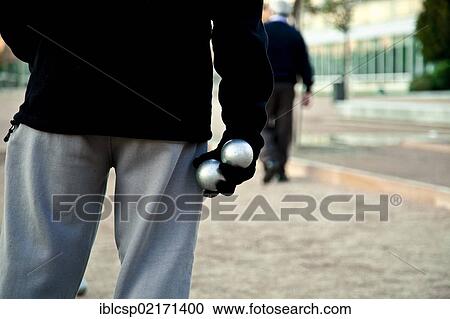 Stock Image - Retiree playing petanca or pétanque in Madrid Rio park, Madrid, Spain, Europe. Fotosearch