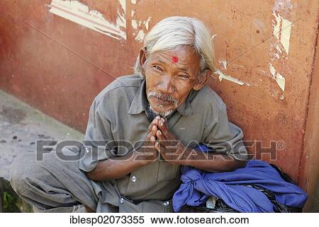 Stock Photography - Seated man with his hands together in a prayer gesture, near Pashupatinath, Kathmandu, Nepal, Asia. Fotosearch