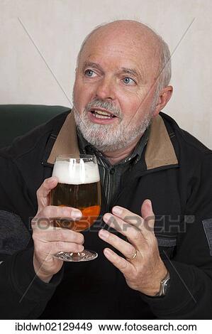 Senior man holding a beer glass View Large Photo Image Stock Photo - Senior man holding a beer glass. Fotosearch