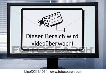 Picture - Sign "Dieser Bereich wird videoueberwacht", German for "this area is under video surveillance", on a computer screen. Fotosearch