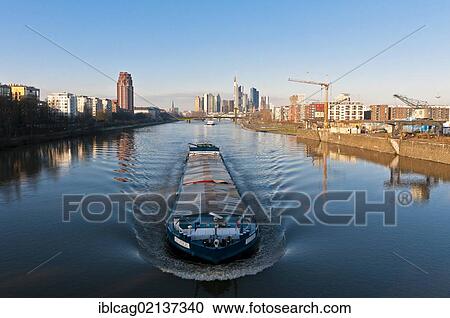 Skyline of Frankfurt with the Main Plaza Tower on the left and a barge on the Main River in the foreground, morning mood, Frankfurt am Main, Hesse, Germany, Europe View Large Photo Image Stock Image - Skyline of Frankfurt with the Main Plaza Tower on the left and a barge on the Main River in the foreground, morning mood, Frankfurt am Main, Hesse, Germany, Europe. Fotosearch