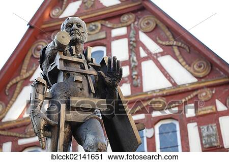 Stock Image - Statue of Goetz von Berlichingen by Gunther Stilling in front of the ornate half-timbered building of the Old Town Hall, Jagsthausen an der Jagst, Hohenlohe, Baden-Wuerttemberg, Germany, Europe, PublicGround, Europe. Fotosearch