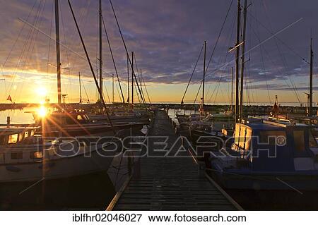 Stock Photo - Sunrise over the yachts at the jetty, Spodsbjerg, Langeland, Denmark, Europe. Fotosearch