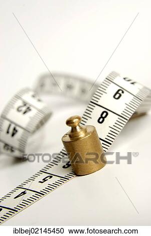 Stock Image - Tape measure and scale weight, symbolic image size and weight. Fotosearch