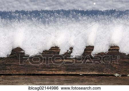 Stock Photograph - Thawing snow with Hoar Frost on a weathered wooden beam, Feldberg Mountain in the Taunus Ranges, Hesse, Germany, Europe. Fotosearch