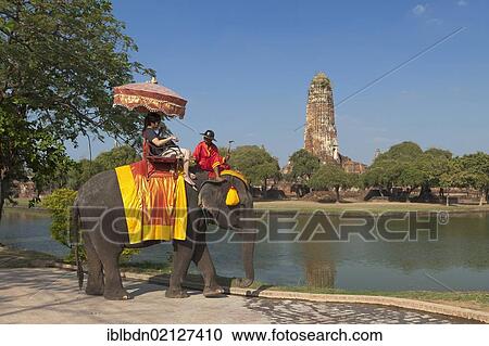 Stock Image - Tourists riding an elephant in front of the Wat Phra Ram temple in the Ayutthaya historical park, Ayutthaya, Thailand, Asia. Fotosearch