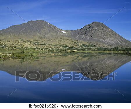 Twin peaks of the mountain group Stygghøin, reflected in Lake Dørålstjørnin, Rondane National Park, Norway, Scandinavia, Europe View Large Photo Image Stock Photo - Twin peaks of the mountain group Stygghøin, reflected in Lake Dørålstjørnin, Rondane National Park, Norway, Scandinavia, Europe. Fotosearch