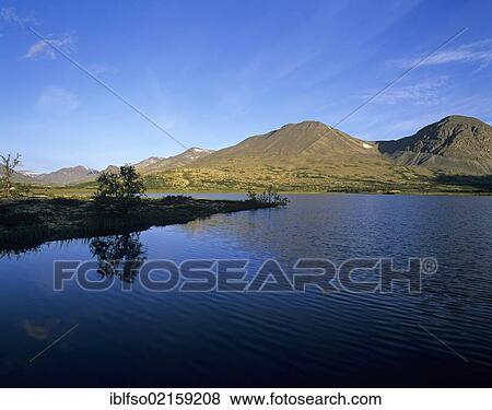 Twin peaks of the mountain group Stygghøin, reflected in Lake Dørålstjørnin, Rondane National Park, Norway, Scandinavia, Europe View Large Photo Image Stock Photo - Twin peaks of the mountain group Stygghøin, reflected in Lake Dørålstjørnin, Rondane National Park, Norway, Scandinavia, Europe. Fotosearch